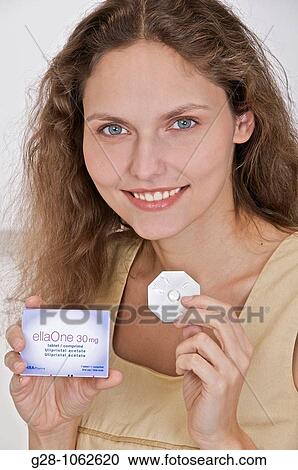 young smiling woman holding ELLA ONE contraceptive pill with its pack View Large Photo Image Stock Image - young smiling woman holding ELLA ONE contraceptive pill with its pack. Fotosearch