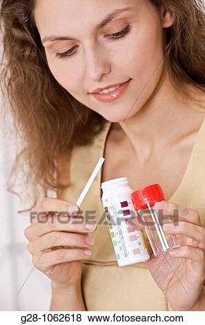 young smiling woman holding urine test tube for analysis, self analysis for diabetes View Large Photo Image Stock Photo - young smiling woman holding urine test tube for analysis, self analysis for diabetes. Fotosearch