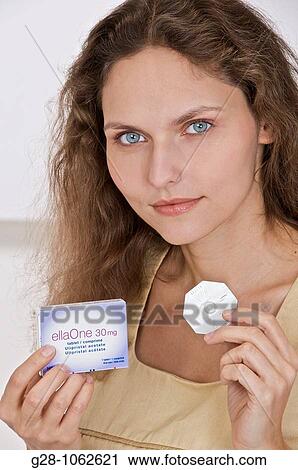 young smiling woman with long hair and blue eyes, holding a pack of ELLA ONE, contraceptive pill, View Large Photo Image Stock Image - young smiling woman with long hair and blue eyes, holding a pack of ELLA ONE, contraceptive pill,. Fotosearch