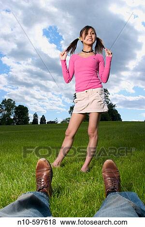 Young Spanish/Asian woman, in pigtails, and a man's legs and feet, posing at a park View Large Photo Image Stock Photo - Young Spanish/Asian woman, in pigtails, and a man's legs and feet, posing at a park. Fotosearch