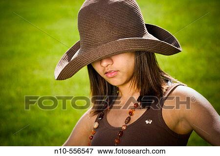 Young Spanish/Asian woman, wearing a hat, posing at a park. View Large Photo Image Stock Photo - Young Spanish/Asian woman, wearing a hat, posing at a park.. Fotosearch