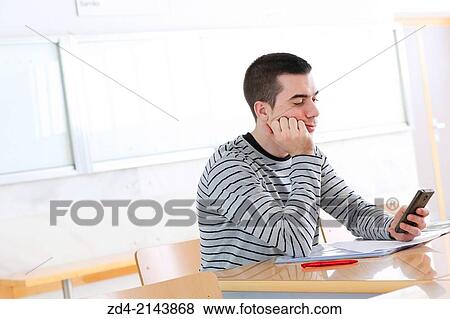 Young student looking at smartphone View Large Photo Image Stock Photo - Young student looking at smartphone. Fotosearch