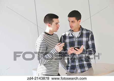 Stock Photo - Young students using smartphone. Fotosearch