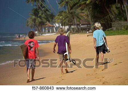 Young surfers walking along Hikkaduwa Beach, Sri Lanka View Large Photo Image Stock Image - Young surfers walking along Hikkaduwa Beach, Sri Lanka. Fotosearch