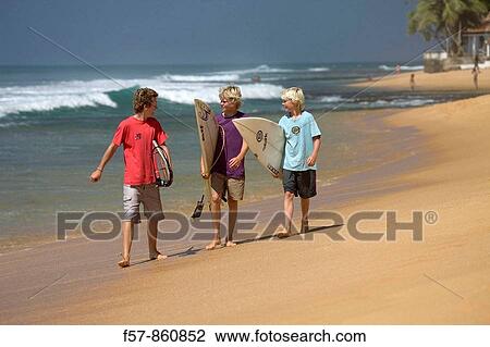 Young surfers walking along Hikkaduwa Beach, Sri Lanka View Large Photo Image Stock Image - Young surfers walking along Hikkaduwa Beach, Sri Lanka. Fotosearch
