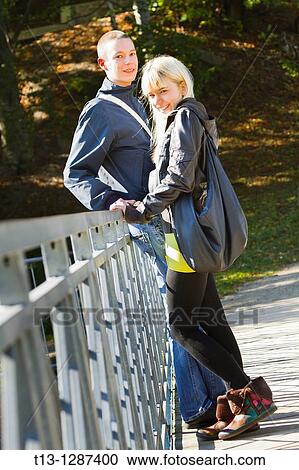 Stock Image - Young teen couple is waiting on a footbridge. Fotosearch