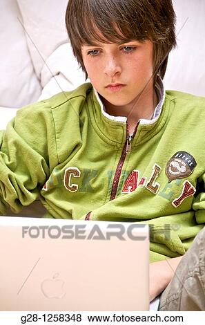 young teenage boy thinking in front of his computer, in a green sweater View Large Photo Image Stock Photo - young teenage boy thinking in front of his computer, in a green sweater. Fotosearch