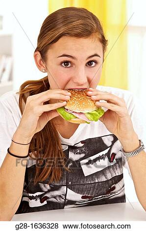 Young teenage girl eating a hamburger with salad View Large Photo Image Stock Photo - Young teenage girl eating a hamburger with salad. Fotosearch
