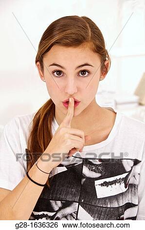 Young teenage girl putting her finger in front of her mouth View Large Photo Image Stock Photograph - Young teenage girl putting her finger in front of her mouth. Fotosearch
