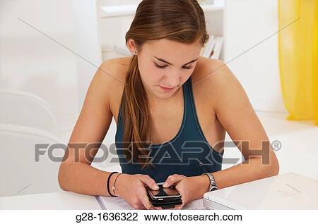 Young teenage girl writing an SMS on her phone View Large Photo Image Stock Image - Young teenage girl writing an SMS on her phone. Fotosearch