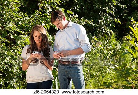 Young teenagers dating boy and girl aged 17 texting on Iphone together at home outdoors. View Large Photo Image Stock Image - Young teenagers dating boy and girl aged 17 texting on Iphone together at home outdoors.. Fotosearch