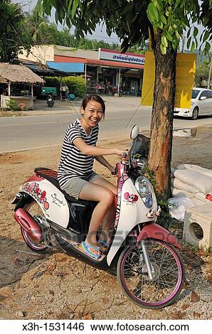 Stock Photograph - Young thai woman with her scooter Krabi, Thailand, Asia. Fotosearch