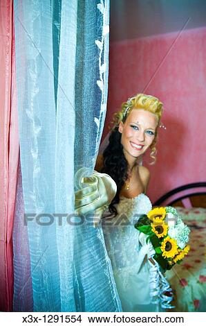 Young wedding bride pushing aside the curtain View Large Photo Image Picture - Young wedding bride pushing aside the curtain. Fotosearch