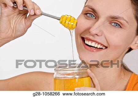young woam holding a jar of liquid honey with wide smile View Large Photo Image Stock Photograph - young woam holding a jar of liquid honey with wide smile. Fotosearch