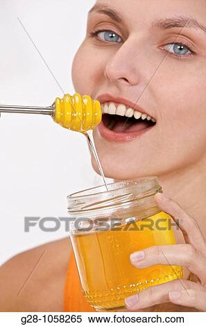 young woam holding a jar of liquid honey with wide smile View Large Photo Image Stock Photography - young woam holding a jar of liquid honey with wide smile. Fotosearch