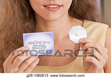 young womam holding ELLA ONE contraceptive pill and pack, lower part of face with lips and smile, long hair View Large Photo Image Stock Image - young womam holding ELLA ONE contraceptive pill and pack, lower part of face with lips and smile, long hair. Fotosearch