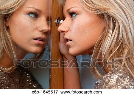 Young woman, 18-25 years, looking through hotel room door security spy peep hole View Large Photo Image Stock Photo - Young woman, 18-25 years, looking through hotel room door security spy peep hole. Fotosearch