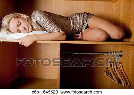 Young woman, 18-25 years, sleeping in wardrobe space in a hotel room View Large Photo Image Stock Image - Young woman, 18-25 years, sleeping in wardrobe space in a hotel room. Fotosearch