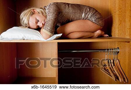 Young woman, 18-25 years, sleeping in wardrobe space in a hotel room View Large Photo Image Stock Photo - Young woman, 18-25 years, sleeping in wardrobe space in a hotel room. Fotosearch