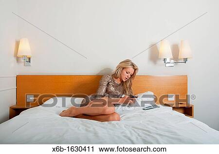 Young woman, 18-25 years, using smartphone in a hotel room View Large Photo Image Stock Image - Young woman, 18-25 years, using smartphone in a hotel room. Fotosearch