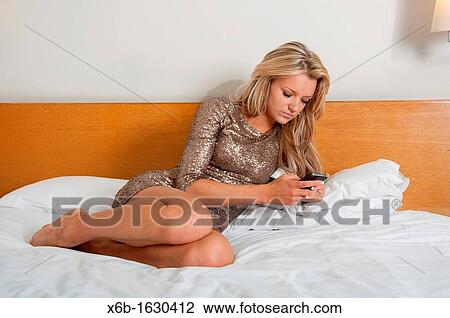 Young woman, 18-25 years, using smartphone in a hotel room View Large Photo Image Stock Image - Young woman, 18-25 years, using smartphone in a hotel room. Fotosearch