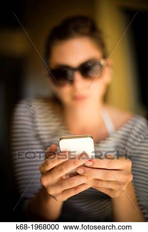 Stock Image - young woman, 21, using a phone.. Fotosearch