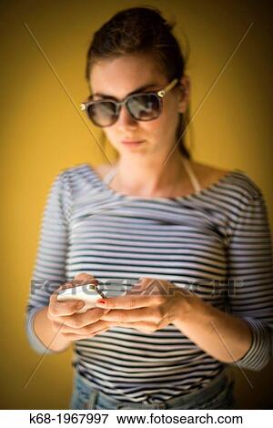 Stock Photo - young woman, 21, using a phone.. Fotosearch
