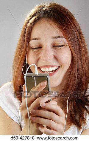 Young woman, 25, laughing while listening to her Ipod View Large Photo Image Stock Photo - Young woman, 25, laughing while listening to her Ipod. Fotosearch