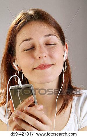 Young woman, 25, listening to her Ipod. View Large Photo Image Stock Photo - Young woman, 25, listening to her Ipod.. Fotosearch