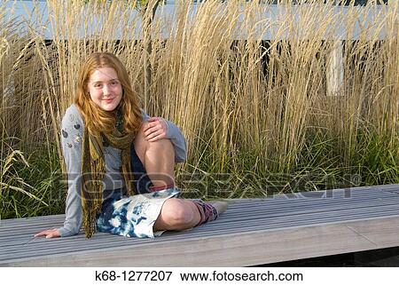 young woman about 20 years of age outdoors with grasses behind her View Large Photo Image Stock Photo - young woman about 20 years of age outdoors with grasses behind her. Fotosearch