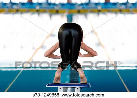 Young woman about to dive in swimming competition View Large Photo Image Stock Photo - Young woman about to dive in swimming competition. Fotosearch