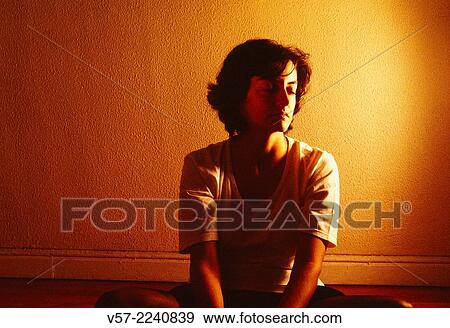 Stock Photo - Young woman alone in a room.. Fotosearch