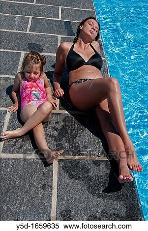 young woman and a little girl relaxing near swimming pool, summertime View Large Photo Image Stock Photography - young woman and a little girl relaxing near swimming pool, summertime. Fotosearch