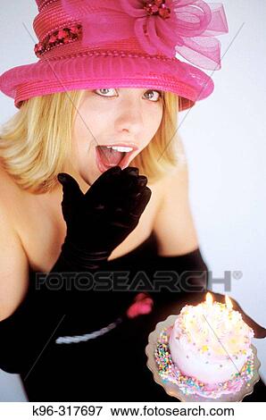 Stock Photo - young woman and birthday cake surprise. Fotosearch