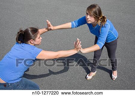 Young woman and teen girl pushing against each other View Large Photo Image Stock Image - Young woman and teen girl pushing against each other. Fotosearch