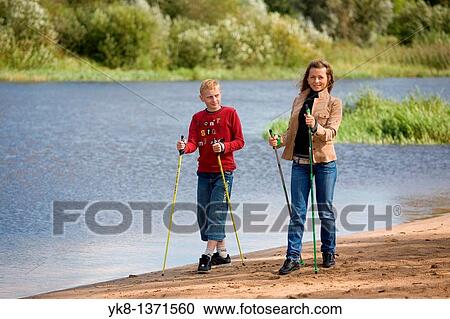 Young woman and teenage boy doing nordic walking by river water View Large Photo Image Stock Image - Young woman and teenage boy doing nordic walking by river water. Fotosearch