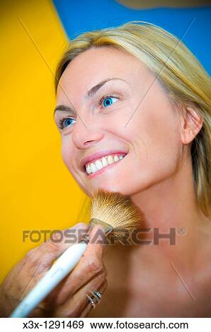 Young woman applying make-up with a brush View Large Photo Image Stock Photo - Young woman applying make-up with a brush. Fotosearch