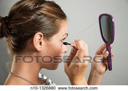 Young woman applying makeup View Large Photo Image Stock Image - Young woman applying makeup. Fotosearch