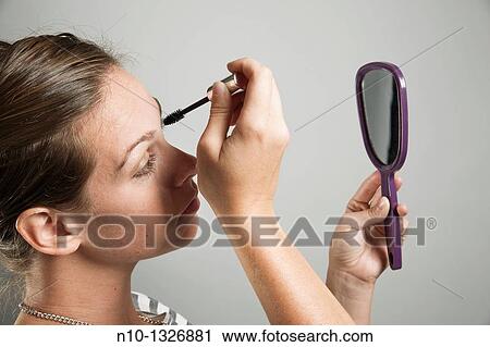 Young woman applying makeup View Large Photo Image Stock Image - Young woman applying makeup. Fotosearch