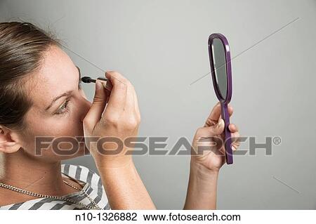 Young woman applying makeup View Large Photo Image Stock Image - Young woman applying makeup. Fotosearch