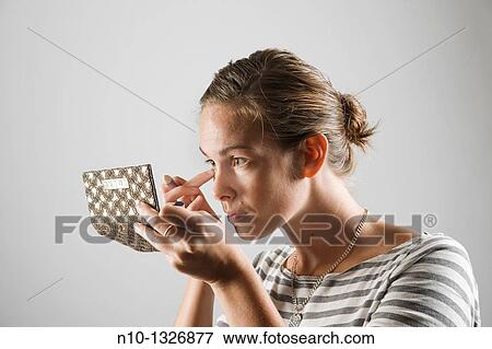 Young woman applying makeup View Large Photo Image Stock Photo - Young woman applying makeup. Fotosearch