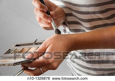 Young woman applying makeup View Large Photo Image Stock Photo - Young woman applying makeup. Fotosearch