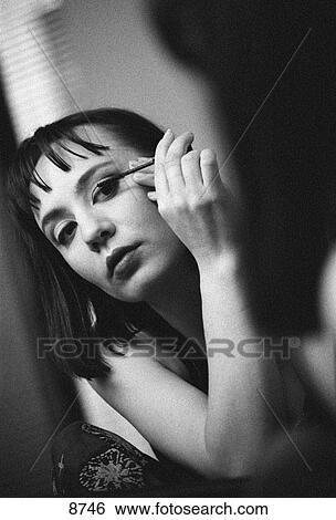 Stock Photograph - Young woman applying mascara. Fotosearch