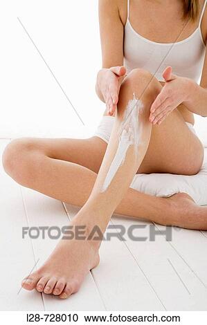 young woman applying moisturizer on her leg View Large Photo Image Stock Image - young woman applying moisturizer on her leg. Fotosearch