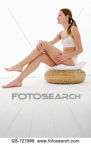 young woman applying moisturizer on her leg View Large Photo Image Stock Photo - young woman applying moisturizer on her leg. Fotosearch