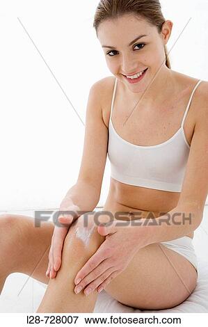 young woman applying moisturizer on her leg View Large Photo Image Stock Photo - young woman applying moisturizer on her leg. Fotosearch