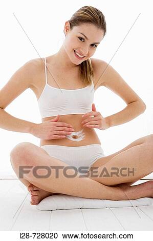 young woman applying moisturizer View Large Photo Image Stock Image - young woman applying moisturizer. Fotosearch