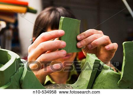 Young woman artist creating a clay sculpture View Large Photo Image Stock Photo - Young woman artist creating a clay sculpture. Fotosearch