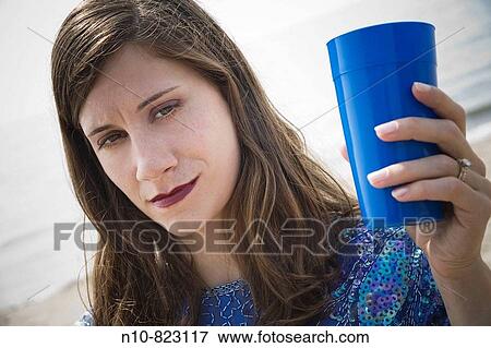 Young woman, at the beach, holding a blue cup. View Large Photo Image Stock Photo - Young woman, at the beach, holding a blue cup.. Fotosearch