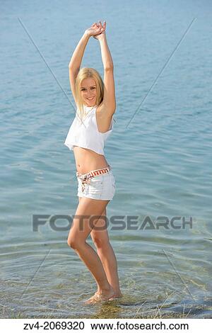 Stock Image - Young woman at the shore of a lake, Austria.. Fotosearch